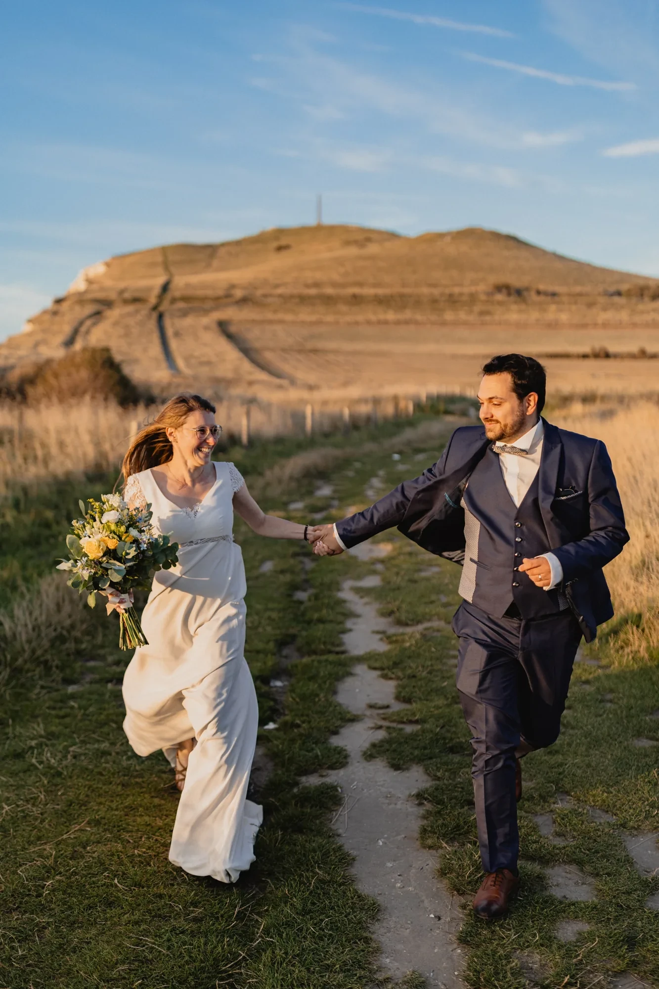newlyweds-running-hillside-path-day-after.webp newlyweds-running-hillside-path-day-after.webp