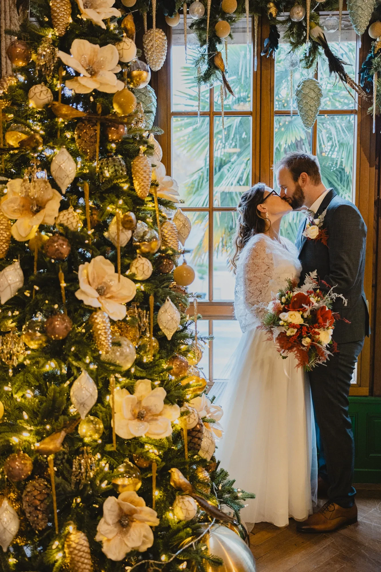 Winter Elopement in Paris – Locations, Timing, Costs 2 newlyweds-kiss-gold-christmas-tree.webp